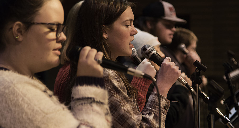 students singing with microphones